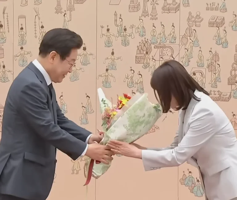 이재명 대통령에게 꽃다발을 건네받는 이태린 여사의 모습